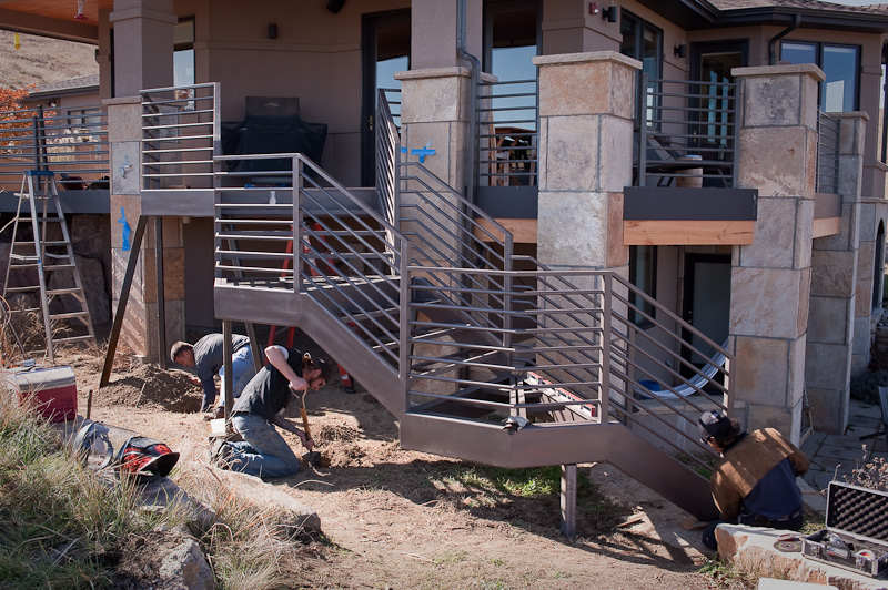 It's bolted to the existing deck, and to a stone landing, and just two support posts are needed (hurrah for metal!).